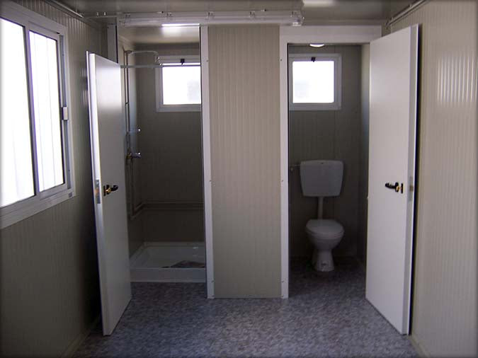 Cabine sanitaire avec toilettes séparées et douche indépendante