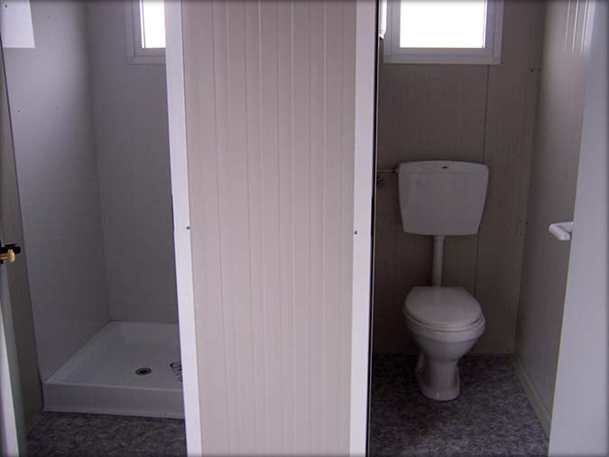 Cabine sanitaire avec toilettes séparées et douche indépendante