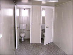 Cabine sanitaire avec toilettes séparées et douche indépendante